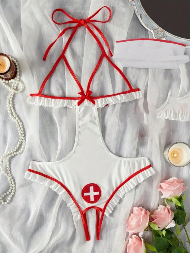 Women's white and red nurse-inspired teddy lingerie with halter straps, ruffle trim, open-back design, matching headband, and playful cosplay style.