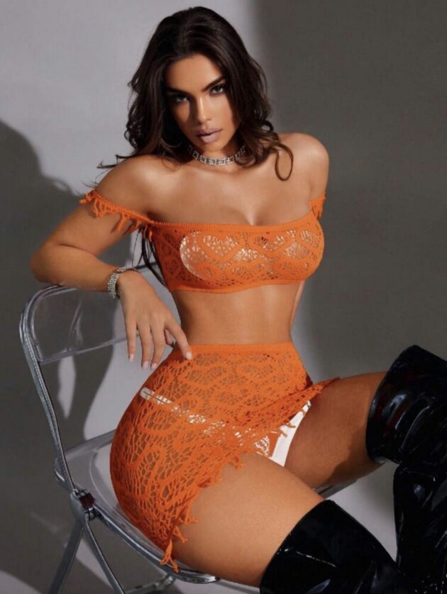Women's orange crochet two-piece beach cover-up set featuring an off-shoulder fringe crop top and matching mini skirt with an open-knit design for beach vacations and summer wear.