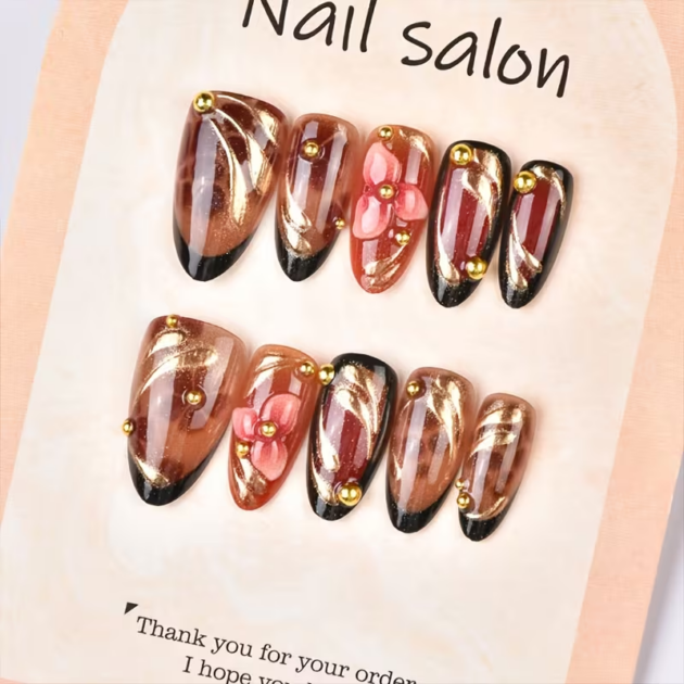 Set of 10 almond-shaped press-on nails featuring brown leopard French tips, metallic accents, and 3D carved red-brown floral nail art.